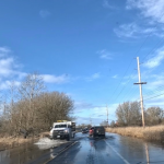 cars drive on flooded road