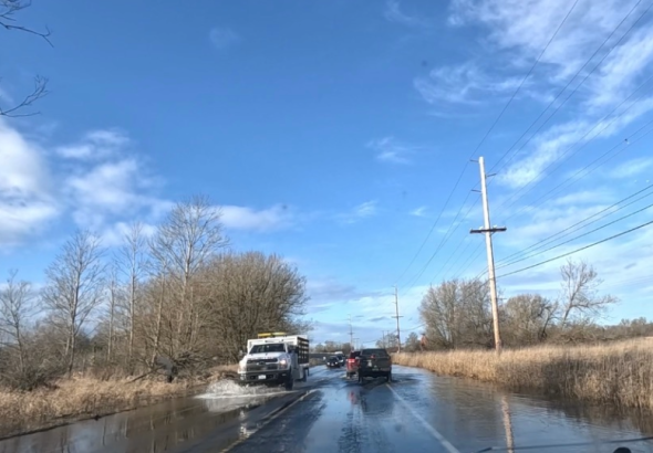 cars drive on flooded road
