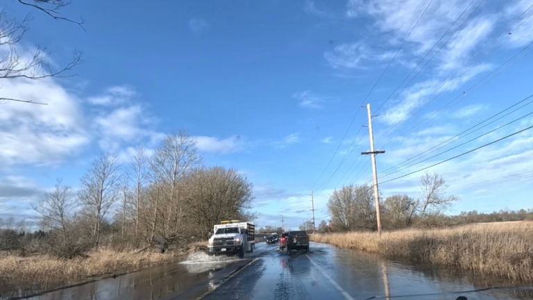 cars drive on flooded road