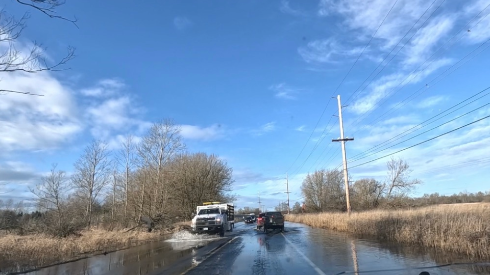 cars drive on flooded road