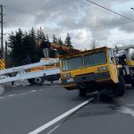 Utility truck tipped sideways blocking Hannegan Road near East Smith Road with emergency crews on scene.