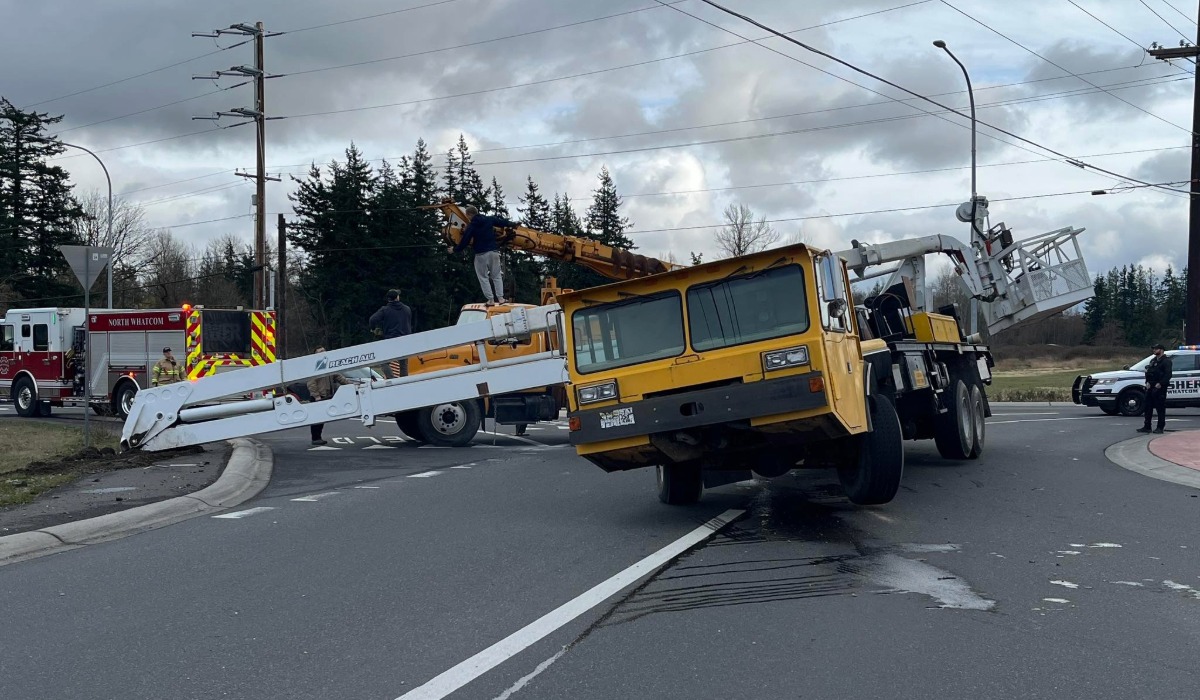 Utility truck tipped sideways blocking Hannegan Road near East Smith Road with emergency crews on scene.