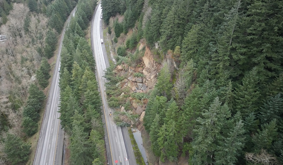 Aerial image of I-5 landslide south of Bellingham with rocks and debris covering roadway and hillside stabilization work underway