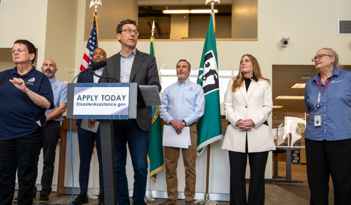 Washington Gov. Bob Ferguson speaks alongside FEMA and local emergency management officials during a disaster assistance press conference in Renton on May 20, 2026, encouraging residents impacted by December flooding to apply for federal aid before the June 10 deadline.