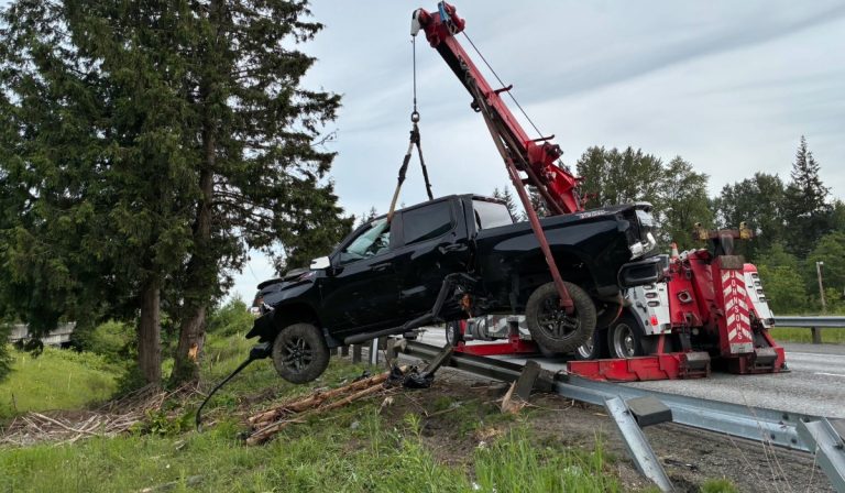 A black pickup is lifted by a tow crane.