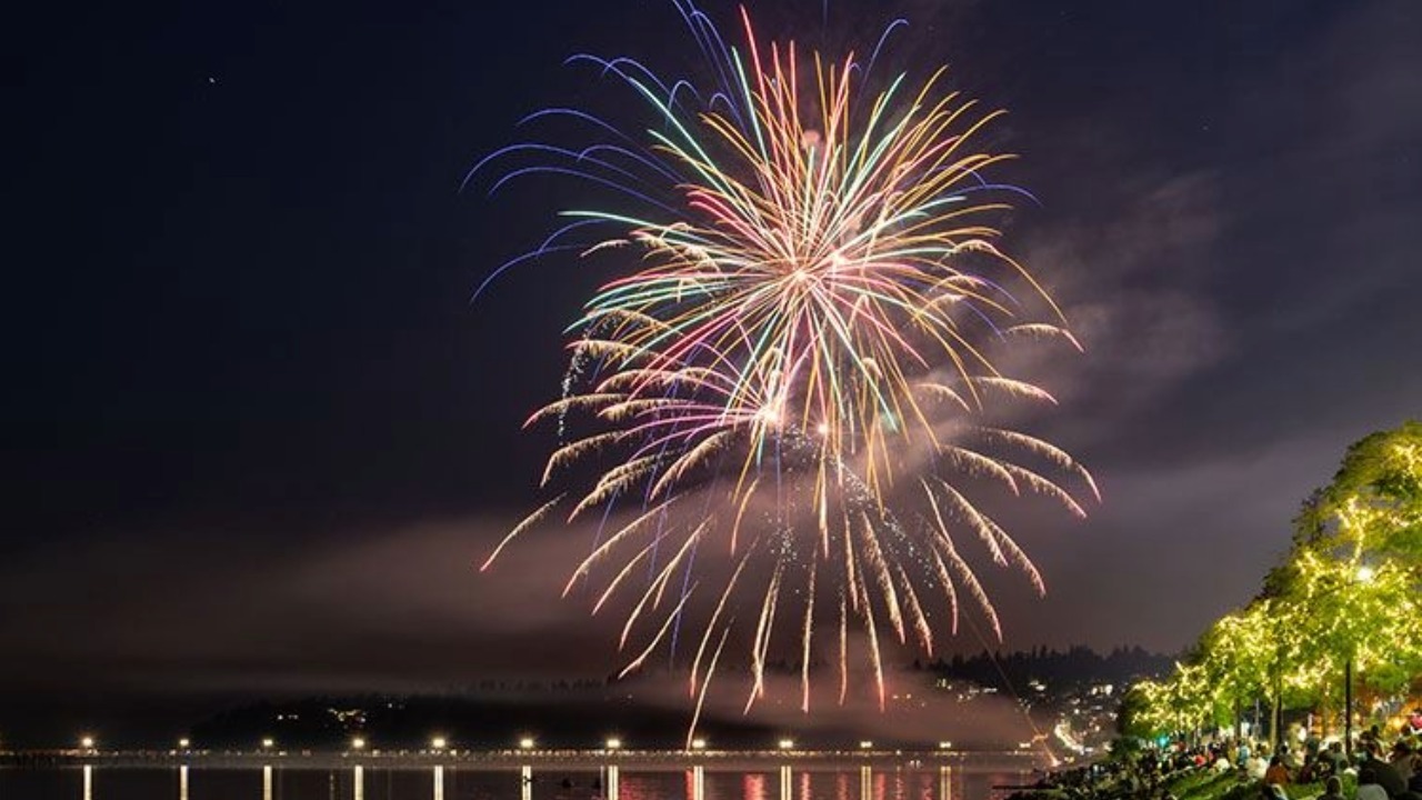 Fireworks explode over Semiahmoo Bay during White Rock's annual Canada Day by the Bay celebration. The display is visible from both White Rock and Blaine across the international border.