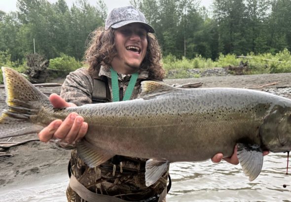 Chris Hamilton holds a buck chinook salmon on Sunday, June 7, 2026.