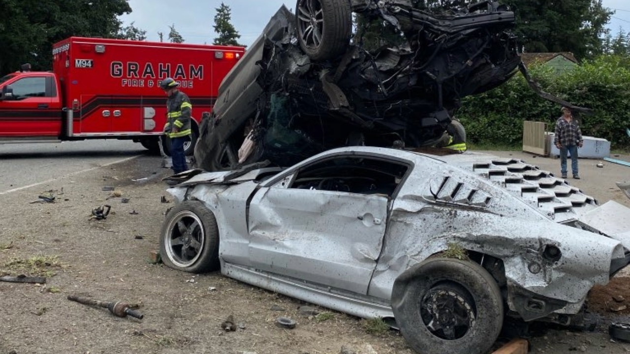Emergency crews respond after a two-vehicle crash at the intersection of State Route 7 and 208th Street East in Spanaway on June 25, 2026. One vehicle came to rest on top of another after the collision and caught fire before Graham Fire crews extinguished the blaze. Authorities reported only minor injuries.