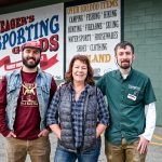 Wyatt Uhrig, left, stands with his mother, Kristin Uhrig, and brother, Jed Uhrig, outside Yeager’s Sporting Goods in Bellingham. Wyatt now serves as the store’s general manager.