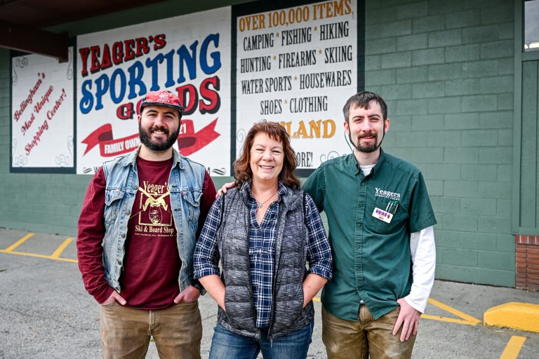Wyatt Uhrig, left, stands with his mother, Kristin Uhrig, and brother, Jed Uhrig, outside Yeager’s Sporting Goods in Bellingham. Wyatt now serves as the store’s general manager.