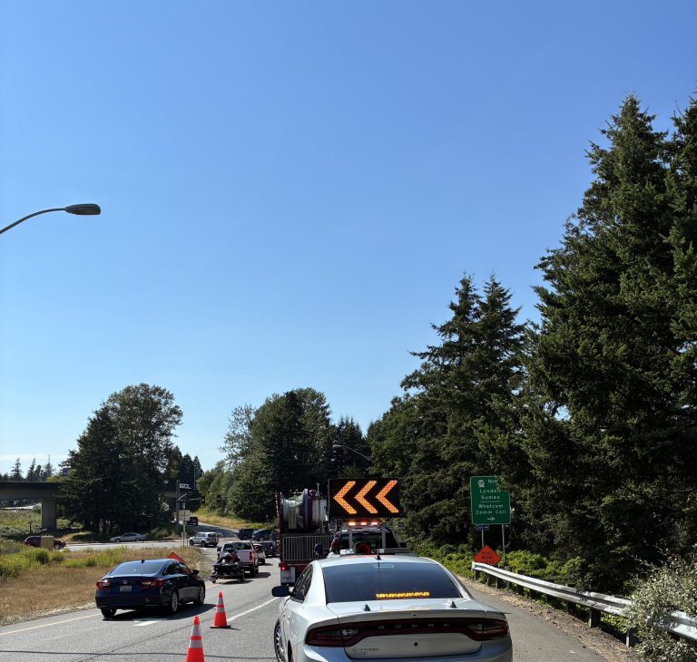 Traffic-control crews direct drivers around a disabled semi at the northbound I-5 exit to SR 539 on Friday, July 24.
