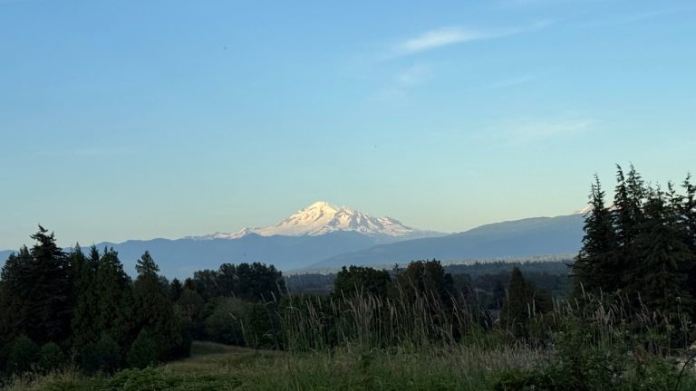 Smoke from wildfires burning across Washington creates a light haze around Mount Baker as Whatcom County prepares to implement a Stage 2 Burn Ban amid elevated wildfire danger and a Red Flag Warning.