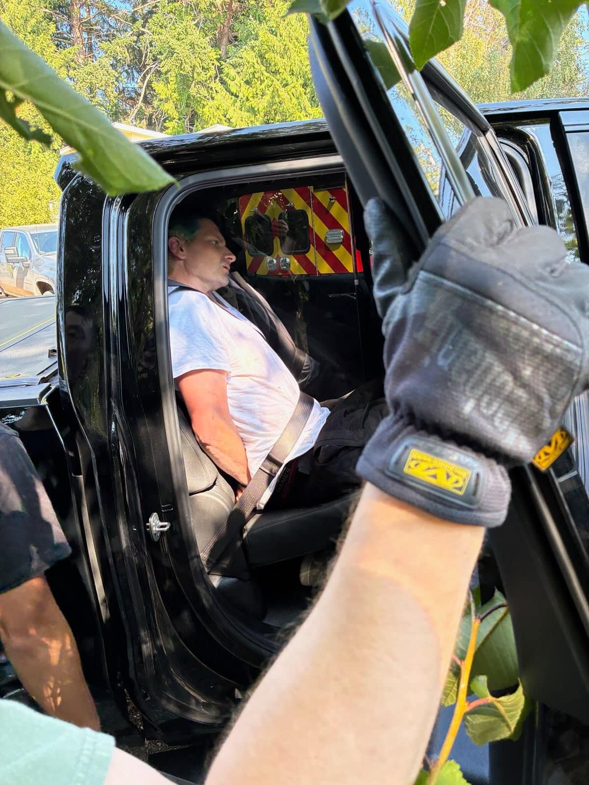 Kyle Hester sits in the back of a county law enforcement vehicle after being taken into custody.