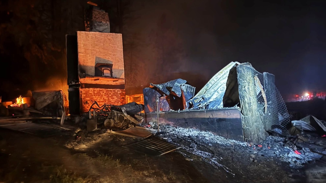 Burned homes and other structures stand among fire-damaged trees following the Spokane Complex fires. Officials estimated that at least 600 structures had been damaged or destroyed as assessment teams began surveying affected neighborhoods.