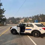 An RCMP vehicle blocks a road leading into an evacuated area of Summerland, B.C., as the Bald Range wildfire burns nearby.