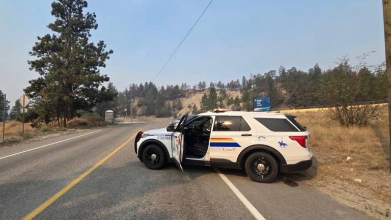 An RCMP vehicle blocks a road leading into an evacuated area of Summerland, B.C., as the Bald Range wildfire burns nearby.