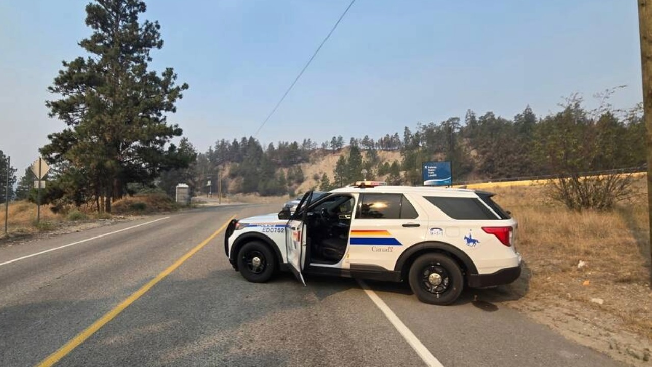 An RCMP vehicle blocks a road leading into an evacuated area of Summerland, B.C., as the Bald Range wildfire burns nearby.