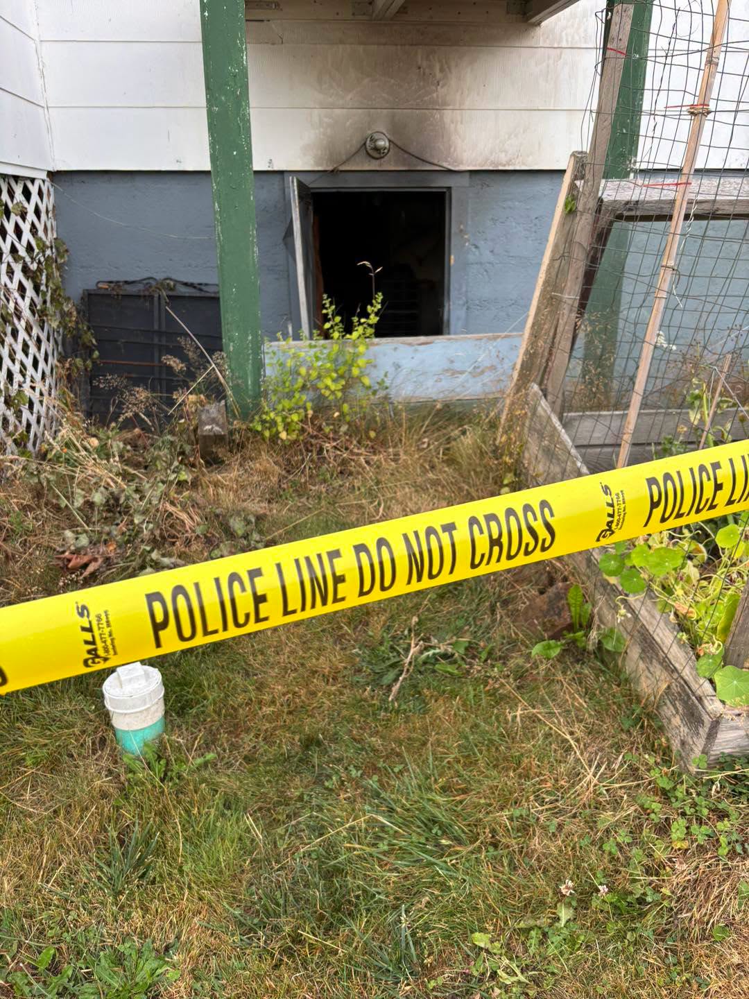 Police tape blocks off a scorched basement entrance at the Bellingham house fire