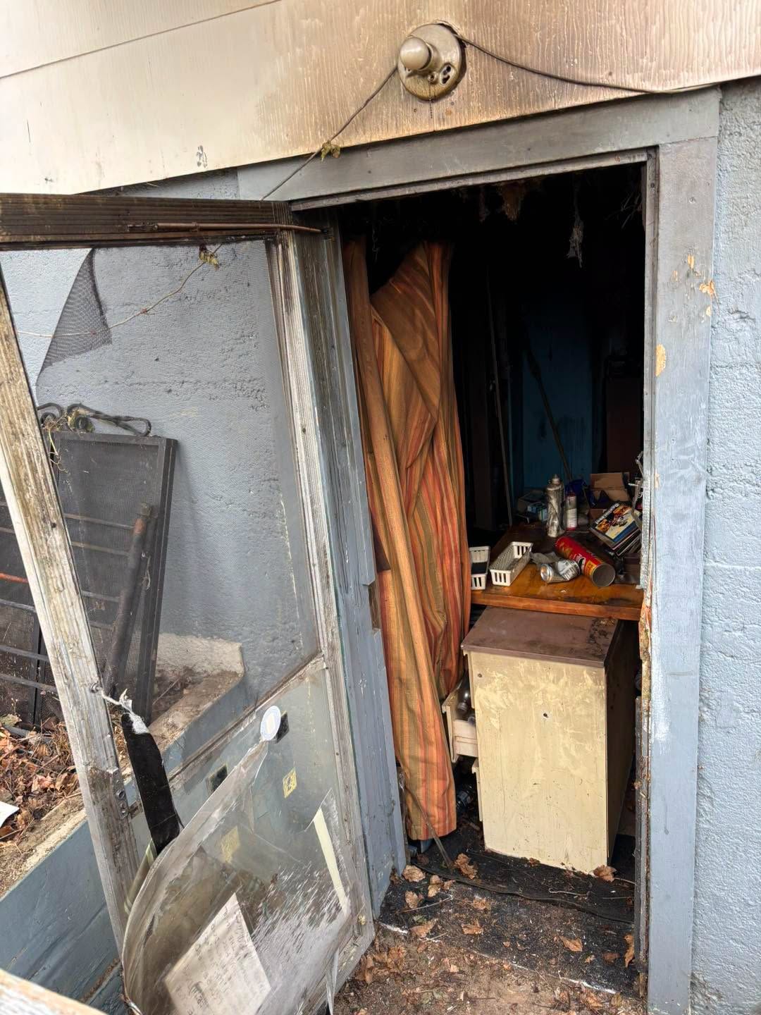 Fire-damaged basement doorway with cluttered interior at the Bellingham house fire scene
