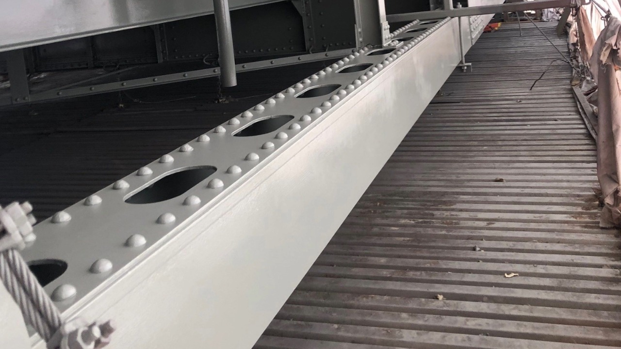 A newly painted steel beam on the SR 536 Skagit River Bridge shows the light gray finish crews are applying to match the bridge's original 1990 color.