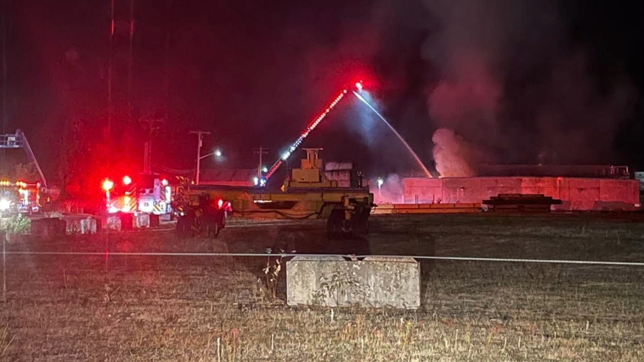 Firefighters used a ladder truck to pour water onto the cold-storage building from above after crews pulled back over roof collapse concerns.