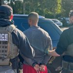 U.S. Marshals take Zealand Adams into custody in Kent, one of two coordinated arrests connected to an alleged home invasion in Alabama.