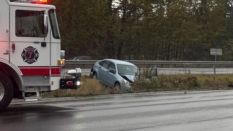 A Whatcom County Fire District 7 engine blocks traffic as a sedan sits in the median on southbound I-5 near Portal Way in Ferndale after Thursday morning’s collision.