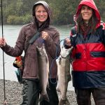 Robin Sheehy, left, and Rebecca Mashhadian show off their coho catches on a September rainy day along one of Washington's salmon rivers.