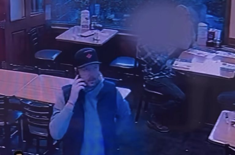 Surveillance footage shows the man the Whatcom County Sheriff's Office is trying to identify, wearing a dark baseball cap, blue jacket and dark pants while using a cellphone.