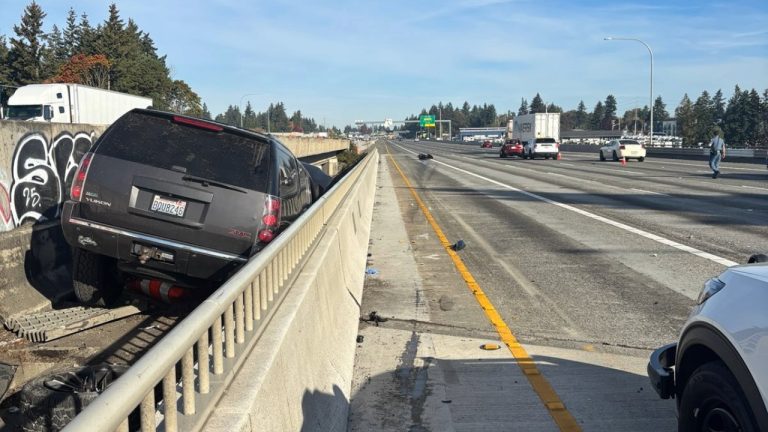 A GMC Yukon sits in the median and a 20-year-old Tacoma motorcyclist faces a reckless driving charge after a three-vehicle crash on I-5 near SR 516 in Kent on Friday morning.